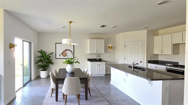 a view of a kitchen with granite countertop lots of counter top space and dining table