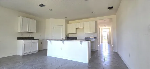 a kitchen with kitchen island sink stove and cabinets