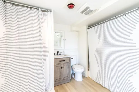 a bathroom with a toilet a sink and a window