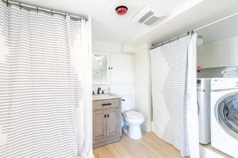 a bathroom with a sink a toilet and a large mirror