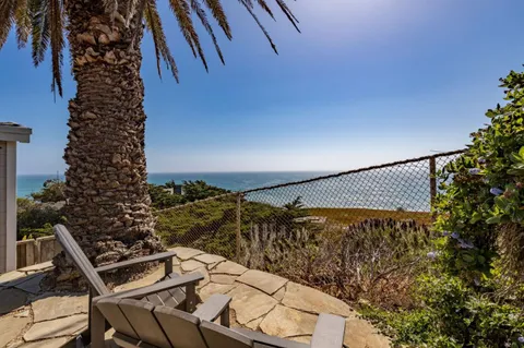 a view of a patio with couches table and chairs and potted plants