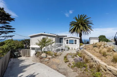 a front view of house with yard and car parked