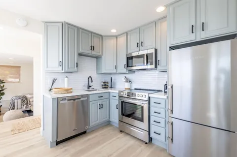 a kitchen with stainless steel appliances granite countertop a refrigerator stove a sink and a microwave