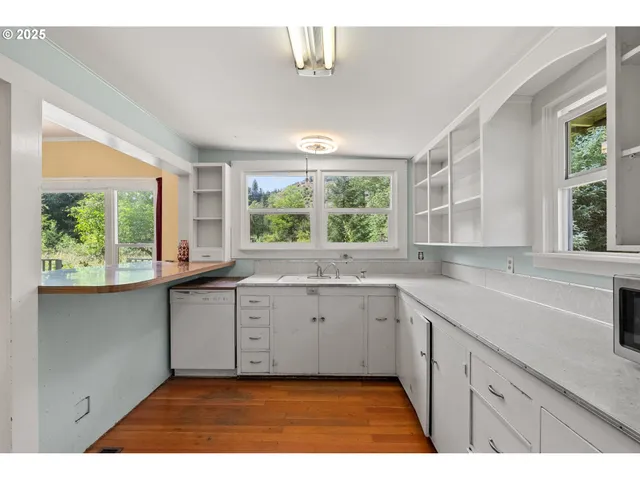 a kitchen with granite countertop a sink window and cabinets