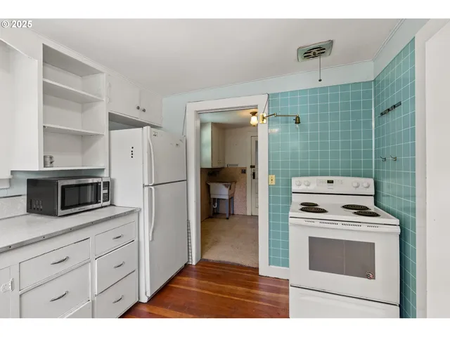 a kitchen with cabinets and white stainless steel appliances