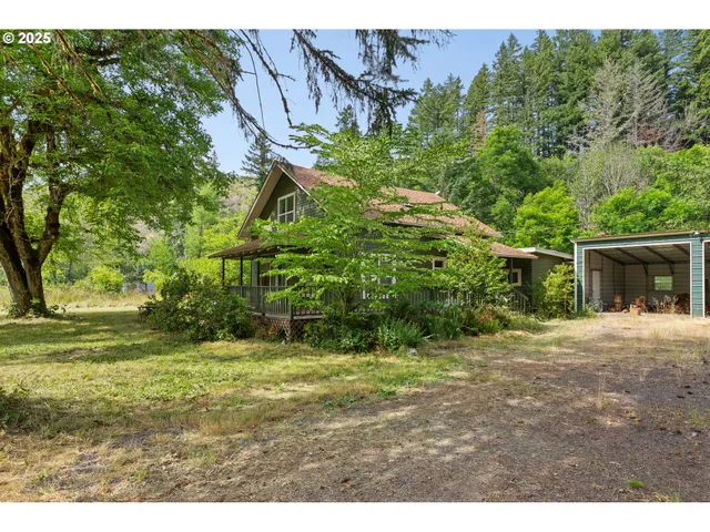 a backyard of a house with a yard and large trees