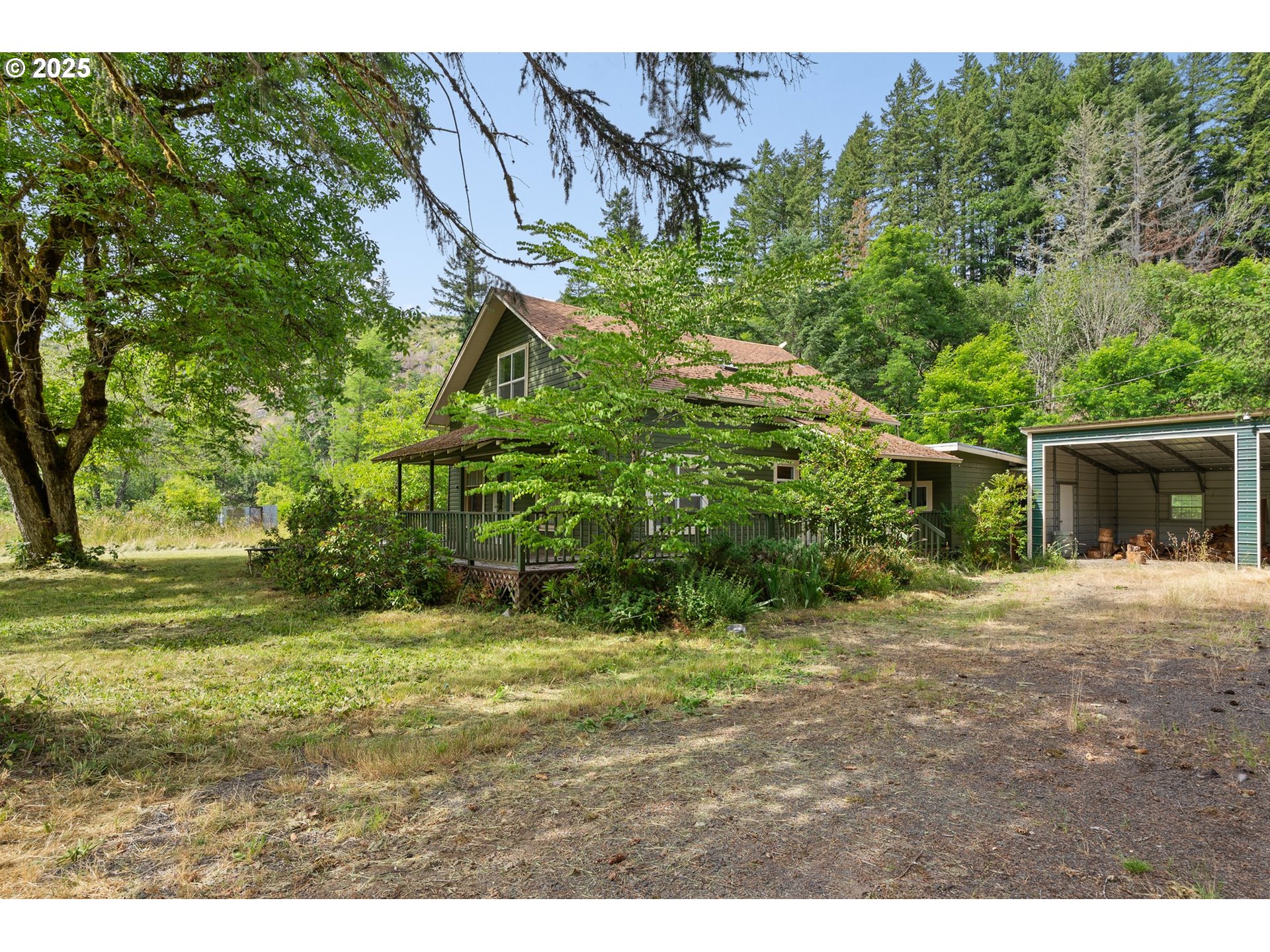 83015 Peninsula Road Fall Creek, OR 97438 - Photo 33 of 40 a backyard of a house with a yard and large trees