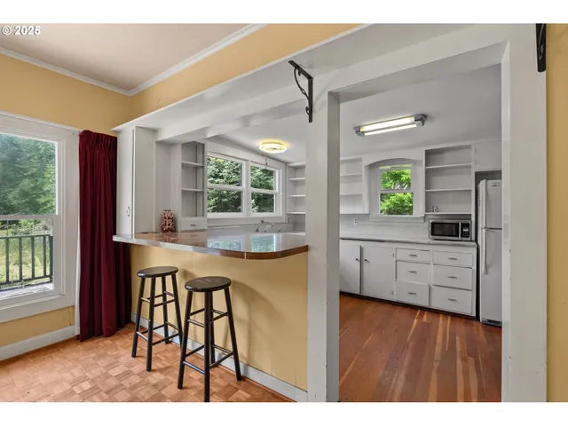 a kitchen with stainless steel appliances a table and chairs in it