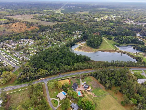 an aerial view of lake and residential houses with outdoor space