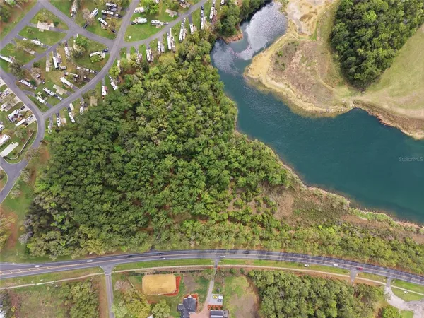 an aerial view of residential houses with outdoor space and trees