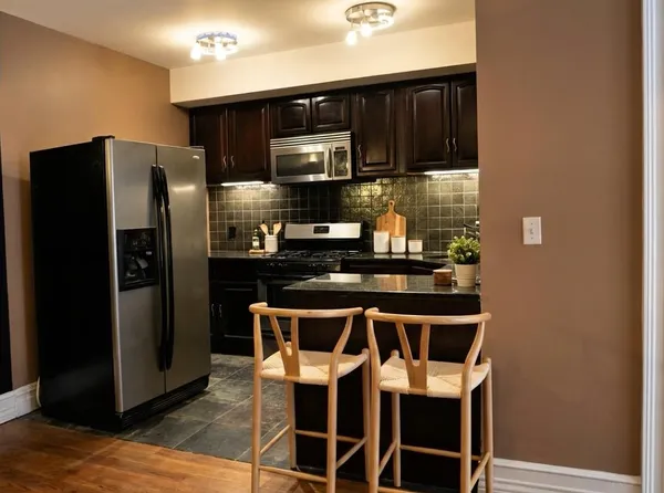 a kitchen with stainless steel appliances a refrigerator and a stove top oven