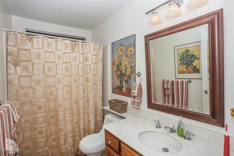 13648 Laurelhurst Road Moorpark, CA 93021 - Photo 20 of 32 a bathroom with a sink a toilet and shower curtain