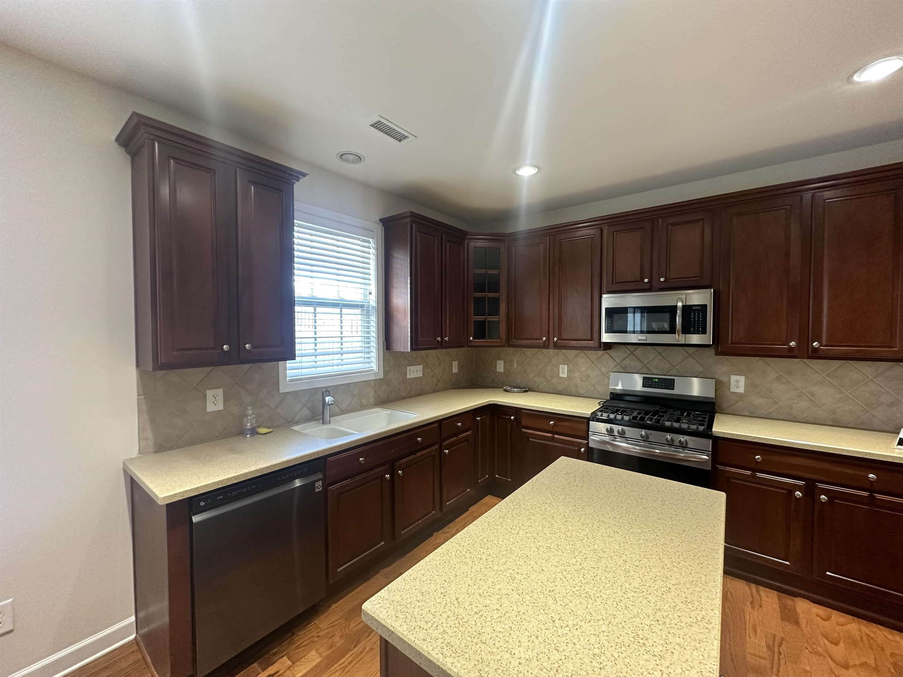 5161 Holly Ridge Farm Road Raleigh, NC 27616 - Photo 12 of 35 a kitchen with stainless steel appliances granite countertop wooden cabinets a stove top oven a sink and dishwasher