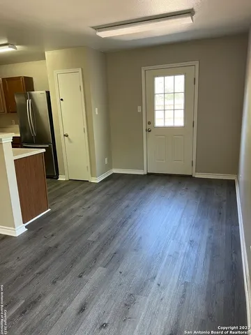 an empty room with wooden floor and a window