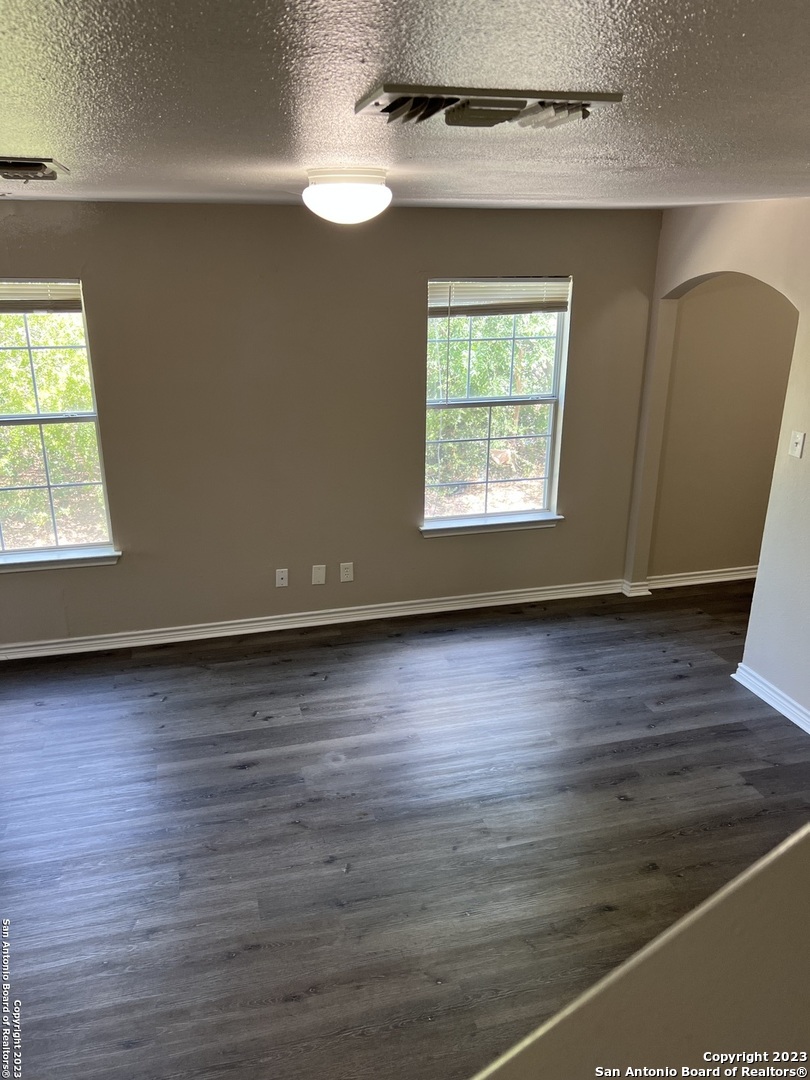 10027 Vasso View, Unit 3 Converse, TX 78109 - Photo 3 of 33 an empty room with wooden floor and windows