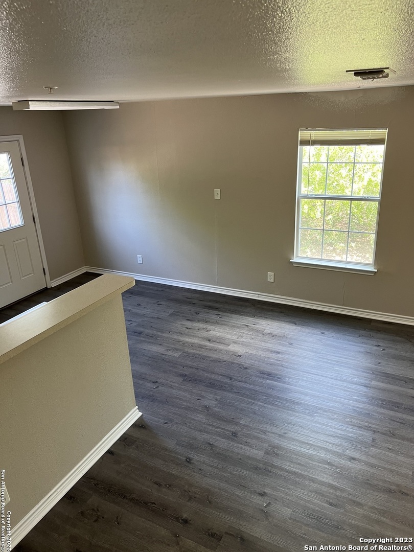 10027 Vasso View, Unit 3 Converse, TX 78109 - Photo 4 of 33 an empty room with wooden floor and windows