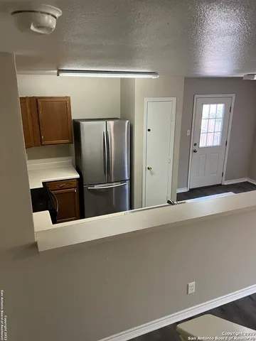 a view of a refrigerator in kitchen and a cabinets