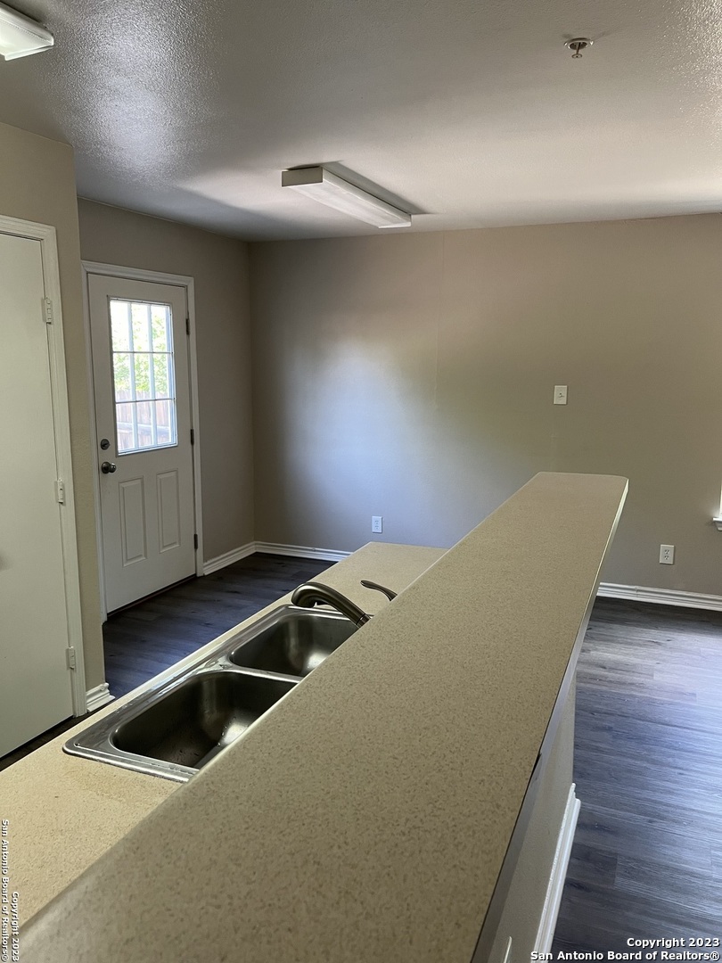 10027 Vasso View, Unit 3 Converse, TX 78109 - Photo 7 of 33 a view of kitchen and empty room with wooden floor