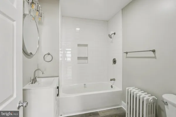 a bathroom with a granite countertop sink a toilet and shower