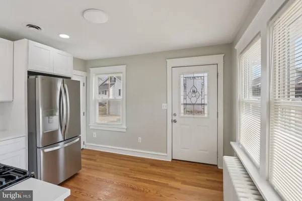 a view of kitchen with refrigerator furniture and wooden floor
