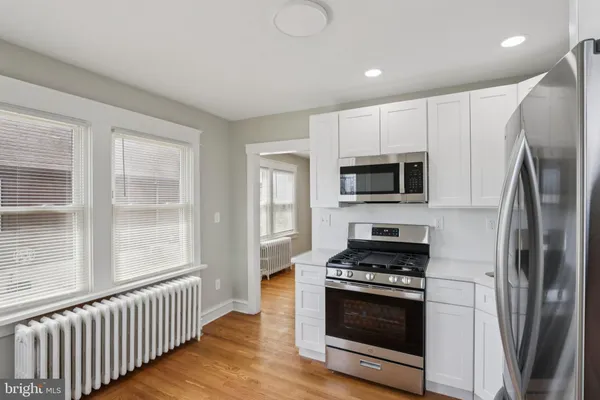 a kitchen with stainless steel appliances granite countertop a stove a microwave and a refrigerator
