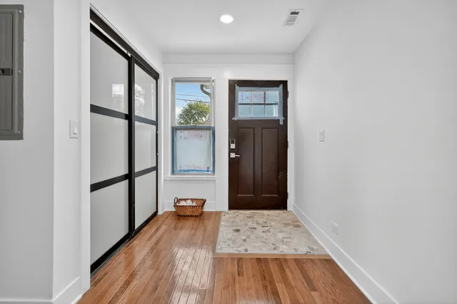 a view of a hallway with wooden floor and staircase