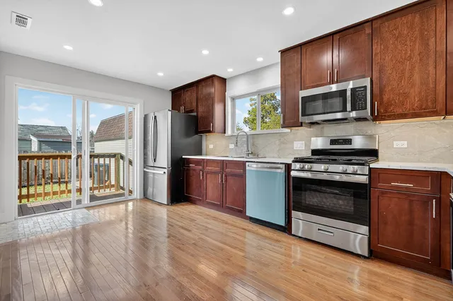 a kitchen with stainless steel appliances kitchen island granite countertop a stove a sink and a refrigerator
