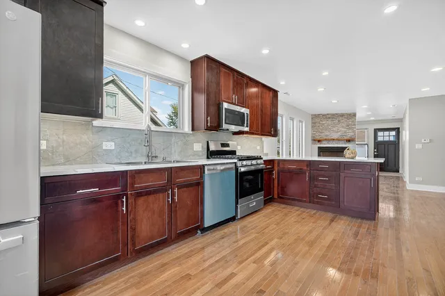 a kitchen with stainless steel appliances granite countertop wooden cabinets and a stove top oven