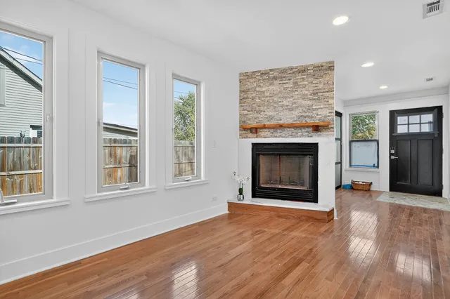 an empty room with windows and a fireplace