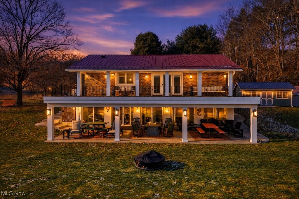 1430 Magnolia Road Southwest Dellroy, OH 44620 - Photo 4 of 50 Stunning twilight view showcasing the home’s impressive outdoor living spaces and warm, inviting ambiance.