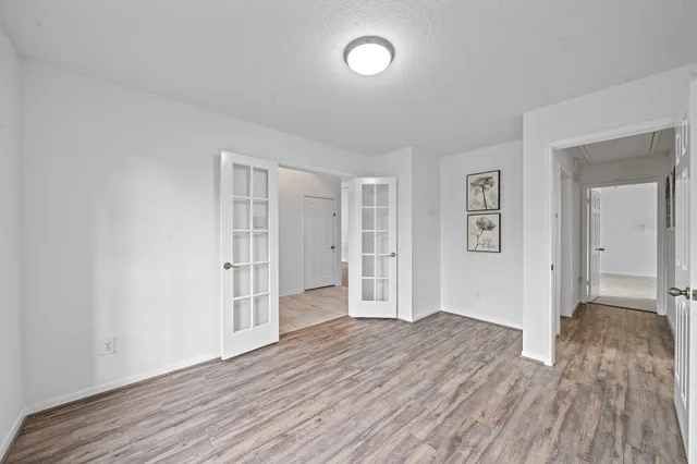 a view of an empty room with wooden floor fireplace and a window