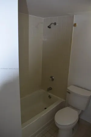 a white toilet sitting next to a bath tub
