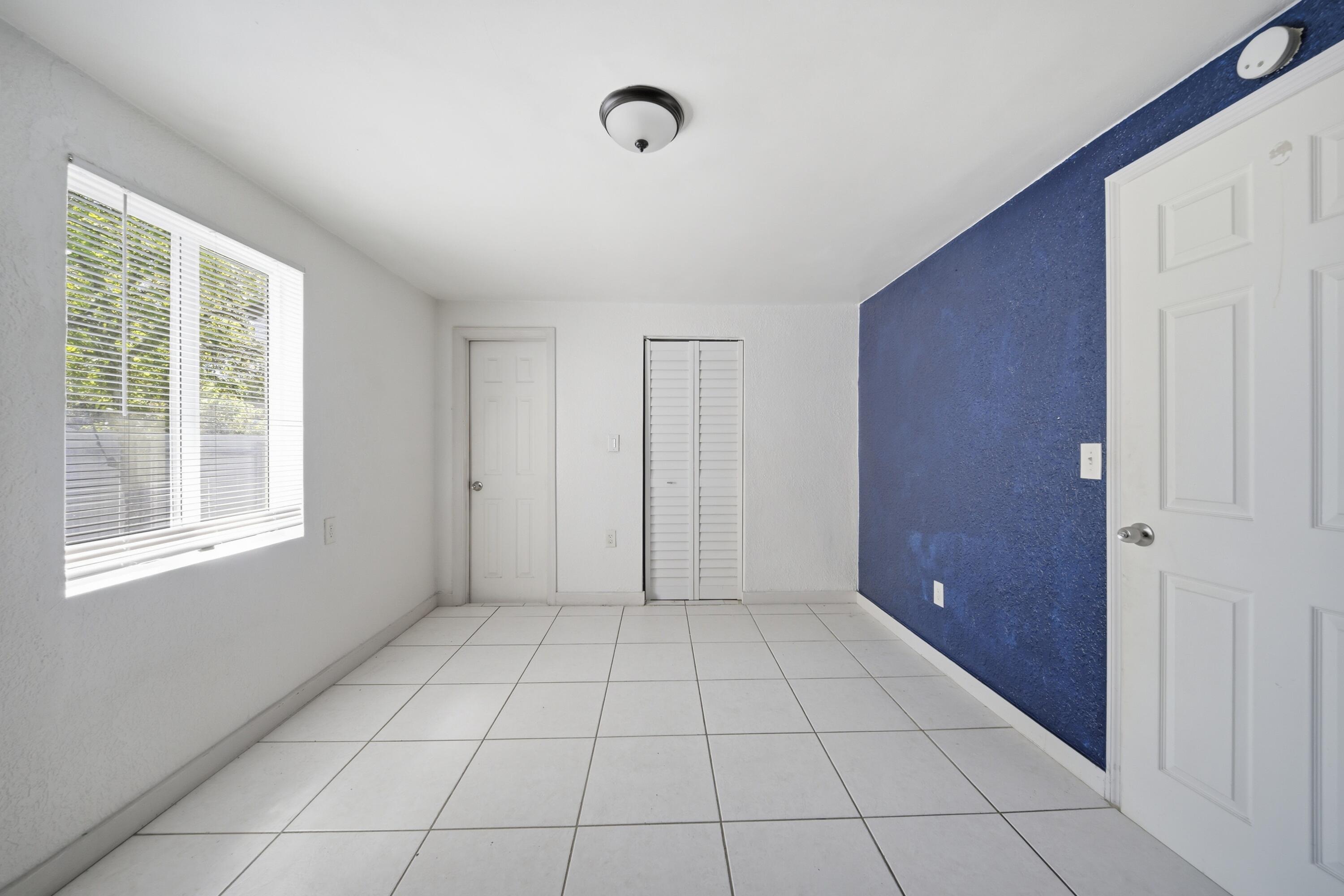 1796 Northwest 112th Street Miami, FL 33167 - Photo 20 of 25 a view of an empty room with window and chandelier fan