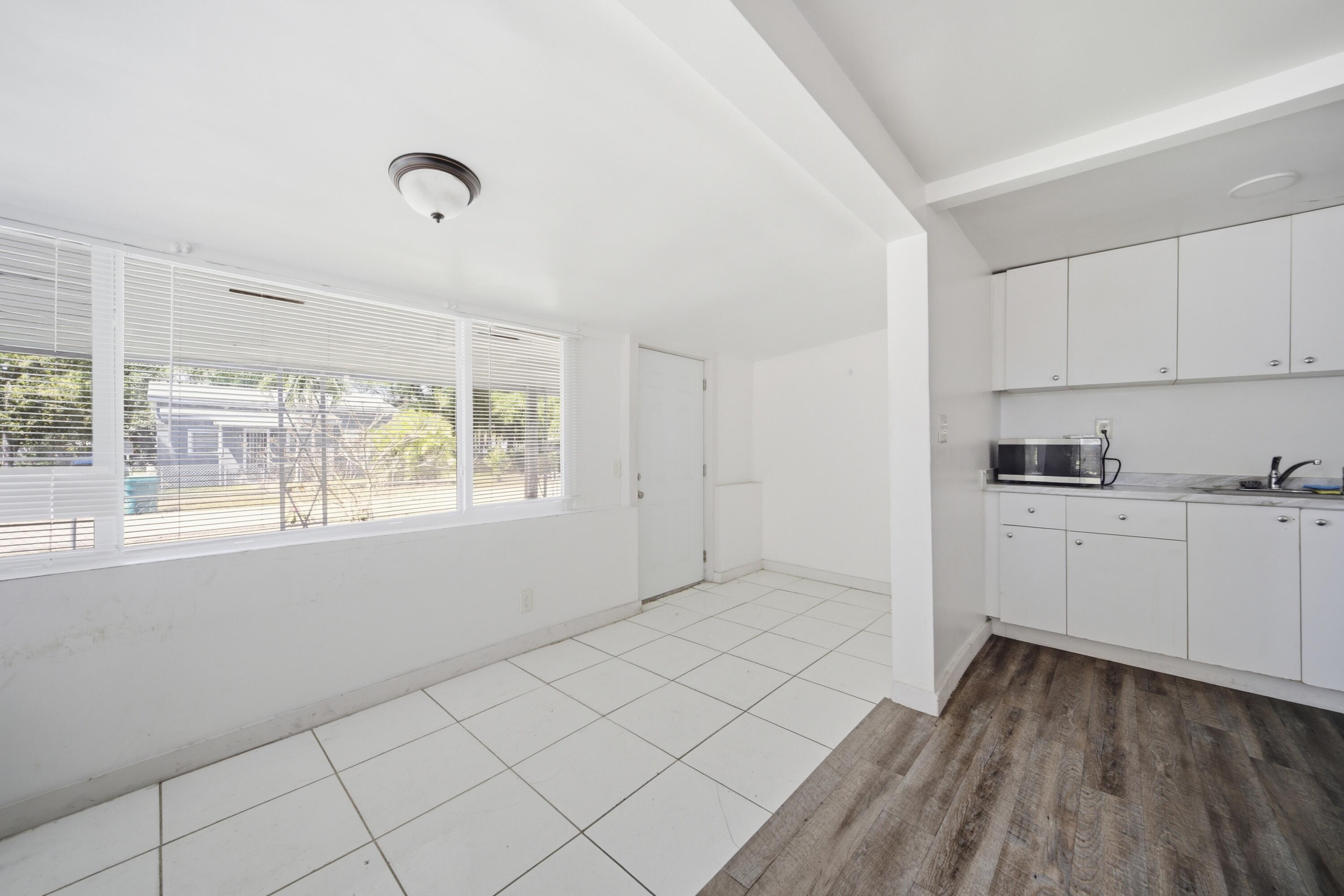 1796 Northwest 112th Street Miami, FL 33167 - Photo 25 of 25 a view of a kitchen with white cabinets and wooden floor