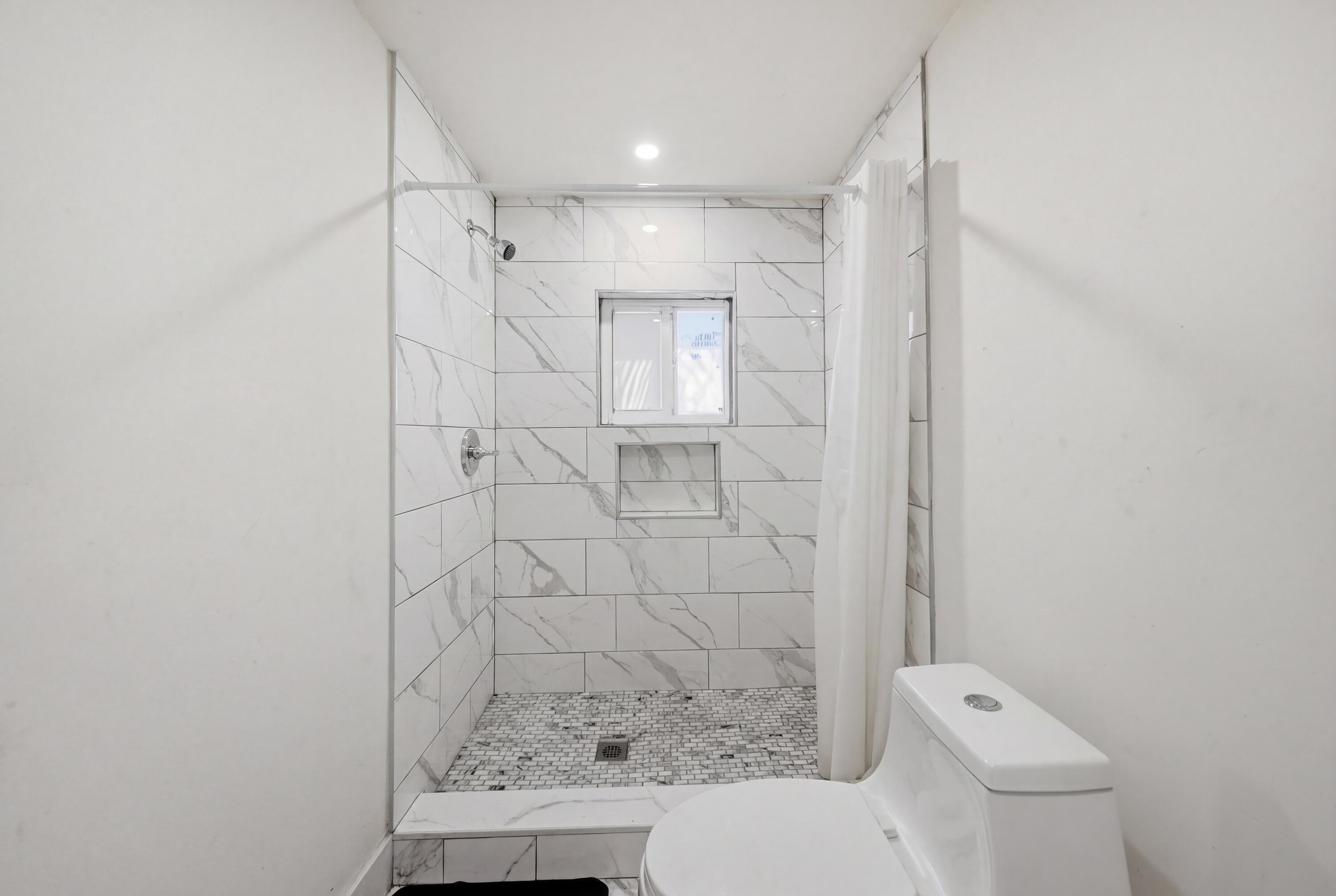 1796 Northwest 112th Street Miami, FL 33167 - Photo 5 of 25 a bathroom with a shower a toilet and sink