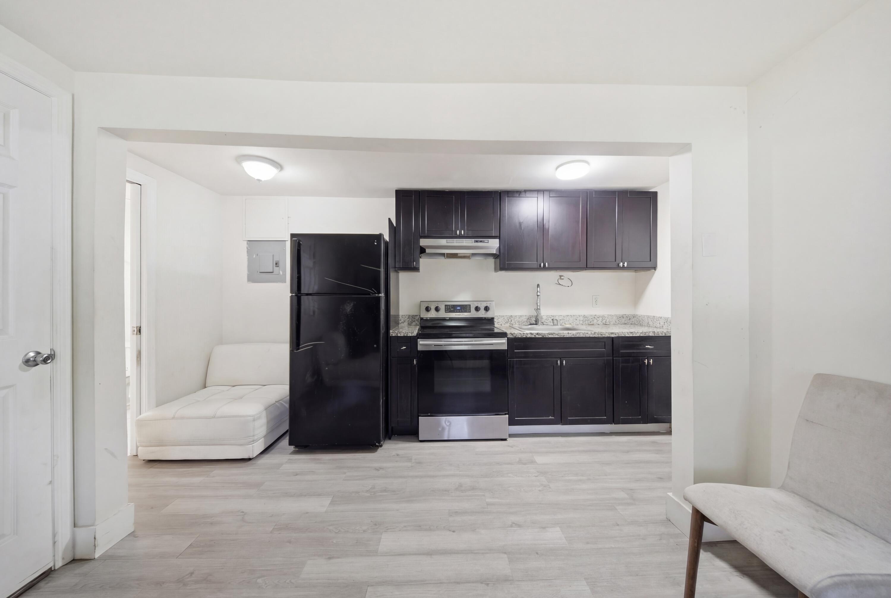 1796 Northwest 112th Street Miami, FL 33167 - Photo 8 of 25 a living room with stainless steel appliances kitchen island granite countertop furniture and a refrigerator
