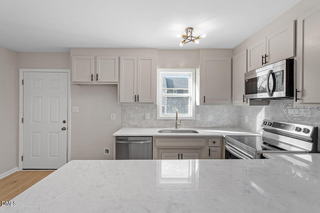 389 East Williams Street Angier, NC 27501 - Photo 11 of 29 a kitchen with stainless steel appliances a sink stove and cabinets