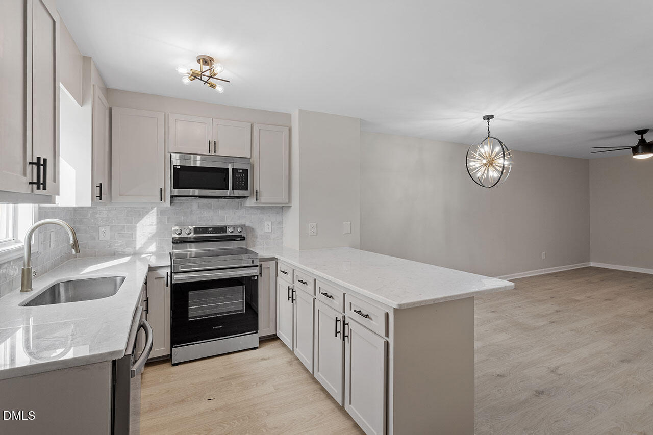 389 East Williams Street Angier, NC 27501 - Photo 13 of 29 a kitchen with stainless steel appliances granite countertop a sink stove and refrigerator