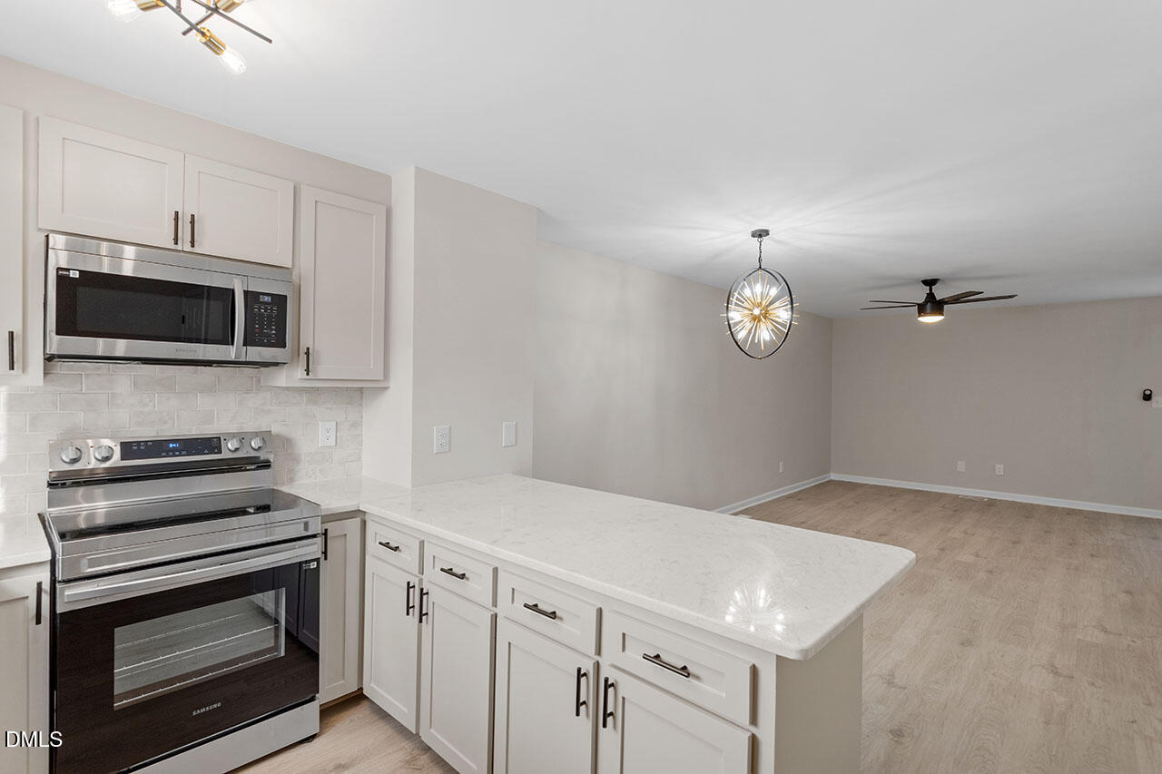 389 East Williams Street Angier, NC 27501 - Photo 9 of 29 a kitchen with cabinets stainless steel appliances and wooden floor