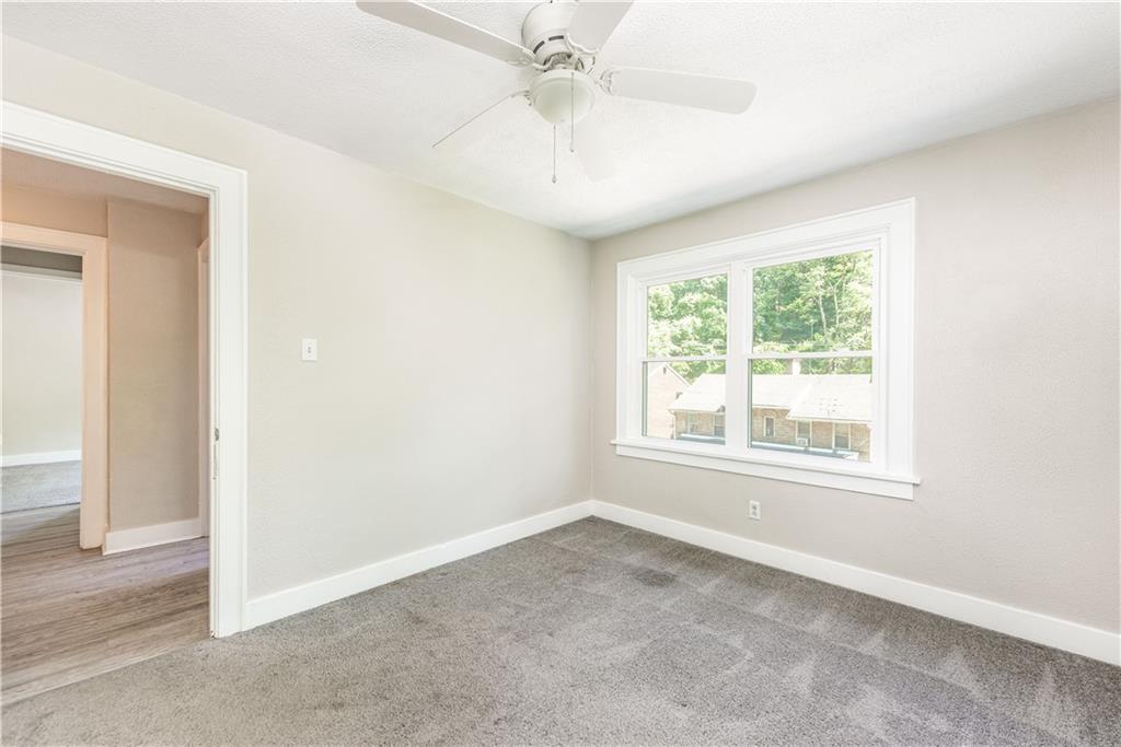 718 Maytide Street Pittsburgh, PA 15227 - Photo 11 of 19 an empty room with a chandelier fan and windows