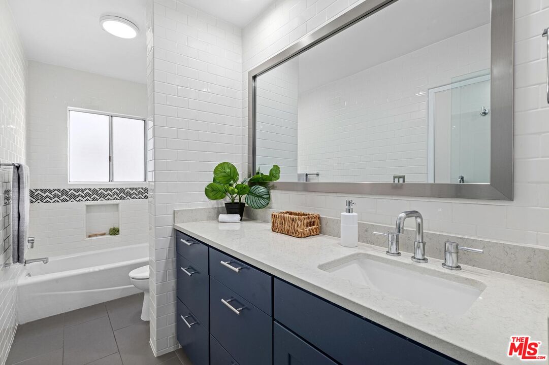 1710 Malcolm Avenue, Unit 101 Los Angeles, CA 90024 - Photo 13 of 18 a bathroom with a tub sink and mirror
