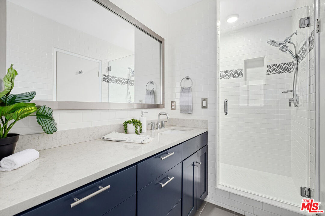 1710 Malcolm Avenue, Unit 101 Los Angeles, CA 90024 - Photo 14 of 18 a bathroom with a sink a mirror and a shower
