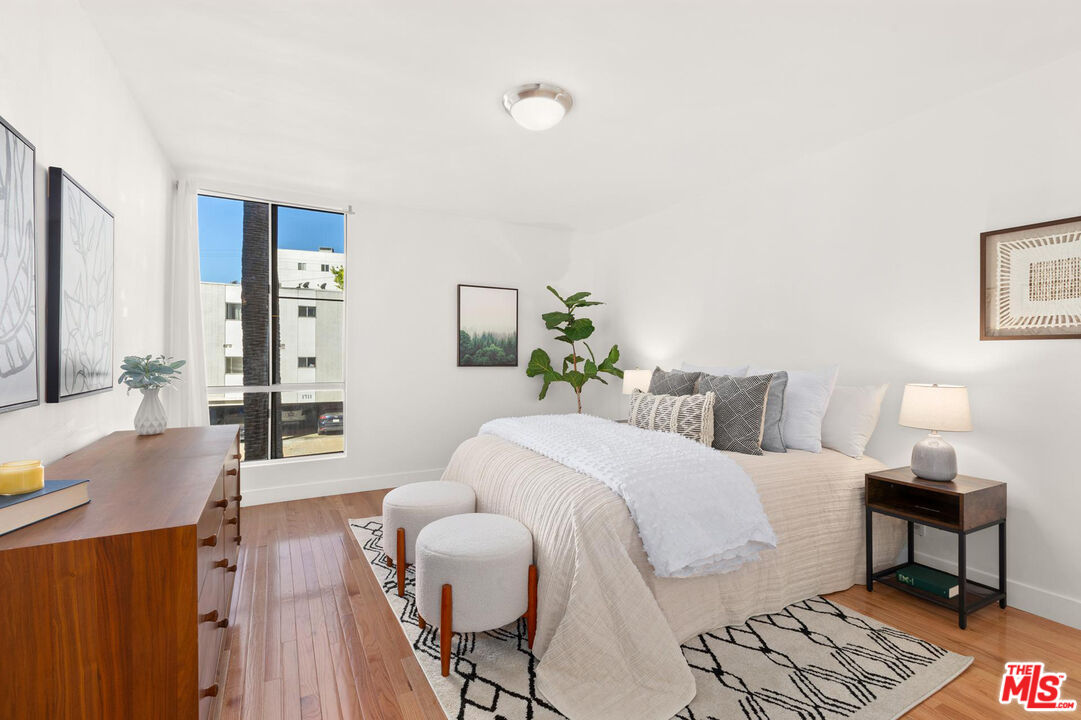 1710 Malcolm Avenue, Unit 101 Los Angeles, CA 90024 - Photo 15 of 18 a bedroom with a bed and wooden floor