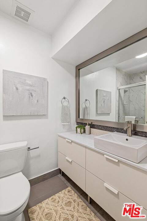 1710 Malcolm Avenue, Unit 101 Los Angeles, CA 90024 - Photo 16 of 18 a bathroom with a toilet sink and mirror