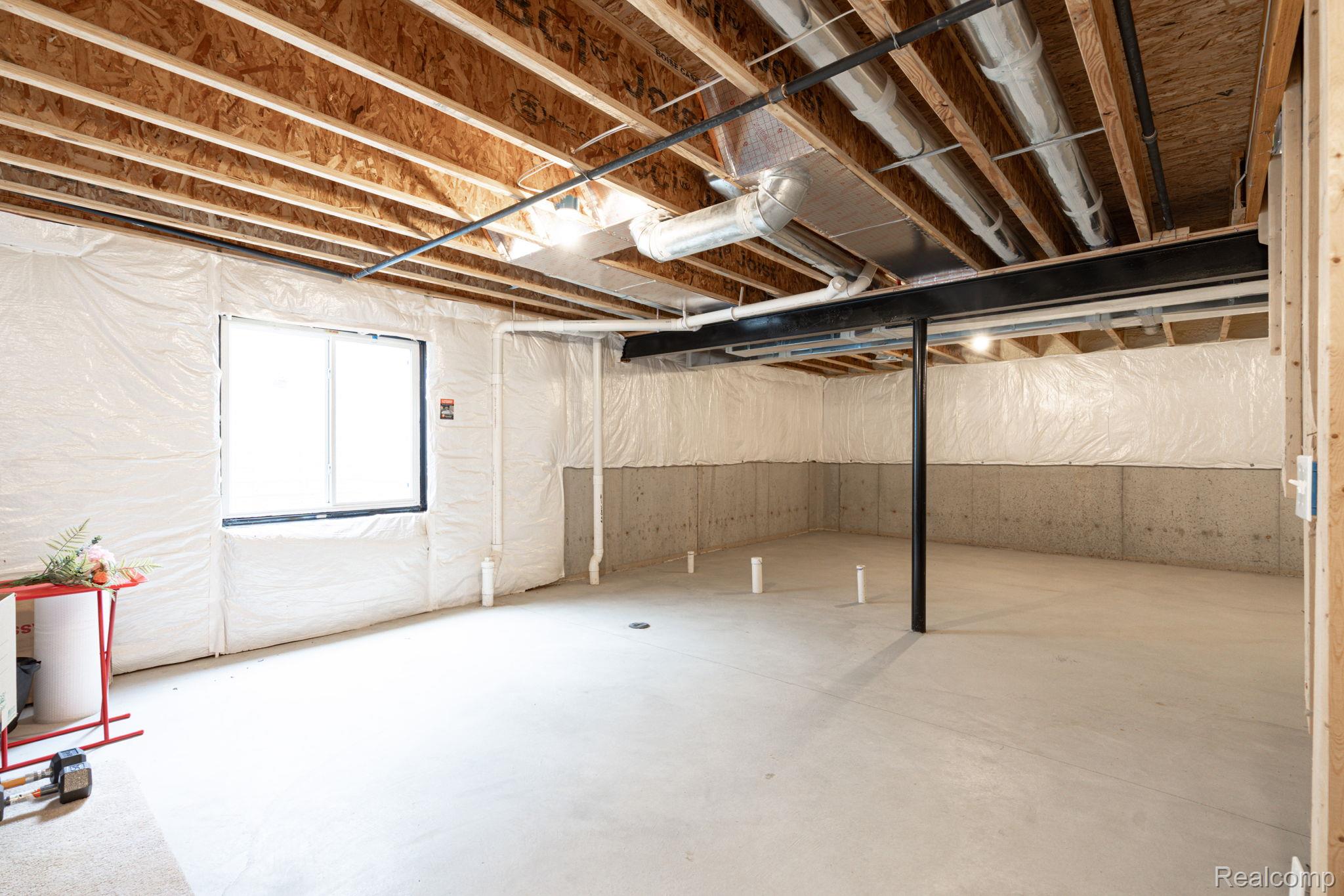 48904 Carnegie Way Macomb, MI 48042 - Photo 31 of 34 Unfinished basement featuring exposed wood joists, concrete foundation walls, and a new egress window
