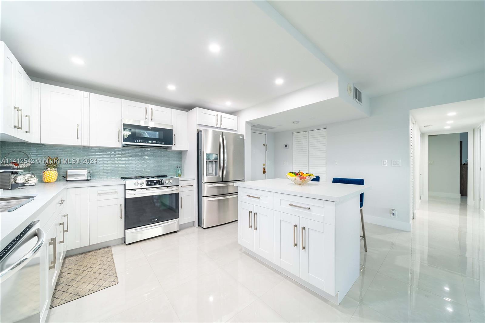 a kitchen with stainless steel appliances cabinets a sink and a refrigerator
