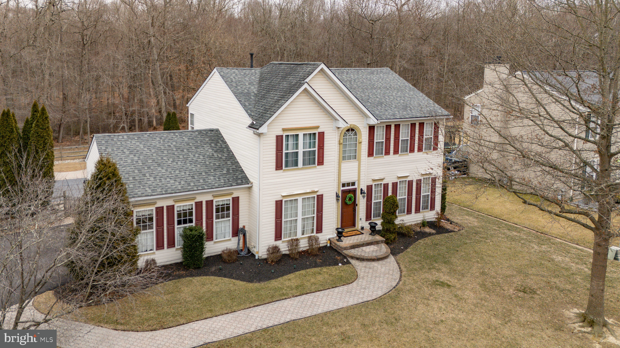 a view of a white house with large windows next to a yard