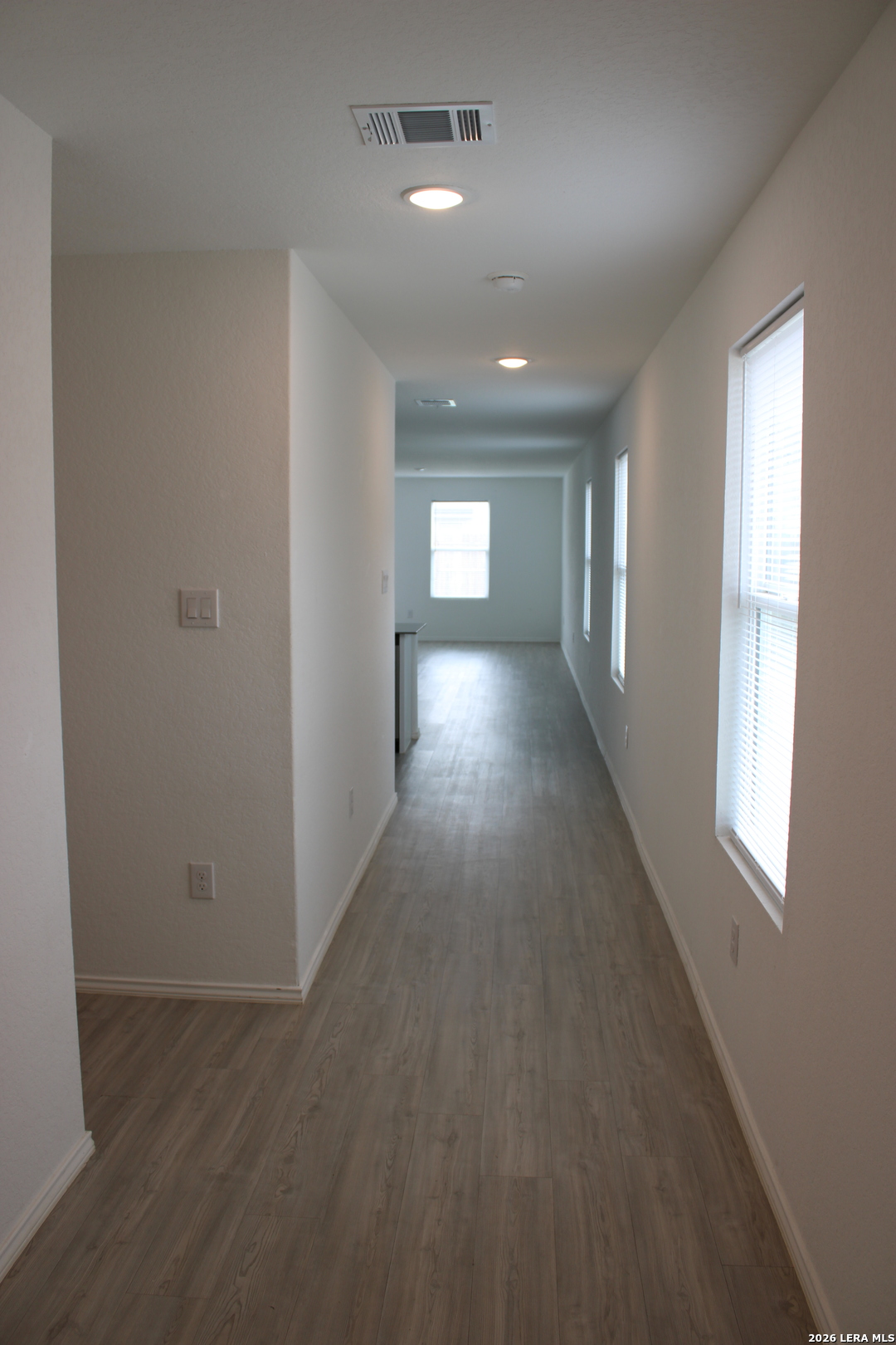 124 Horseshoe Trail Pleasanton, TX 78064 - Photo 2 of 16 an empty room with wooden floor and windows