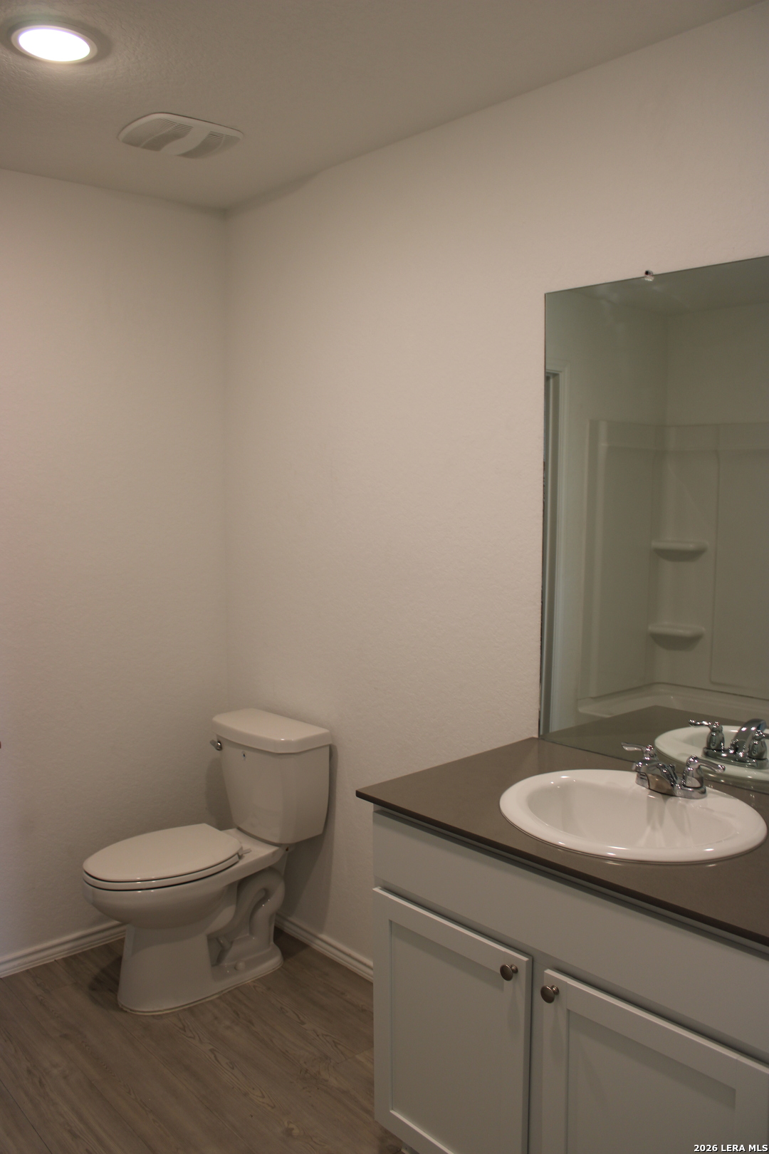 124 Horseshoe Trail Pleasanton, TX 78064 - Photo 10 of 16 a bathroom with a granite countertop toilet a sink and a mirror