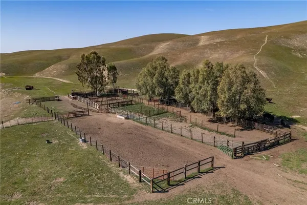 a view of a dry yard with wooden fence